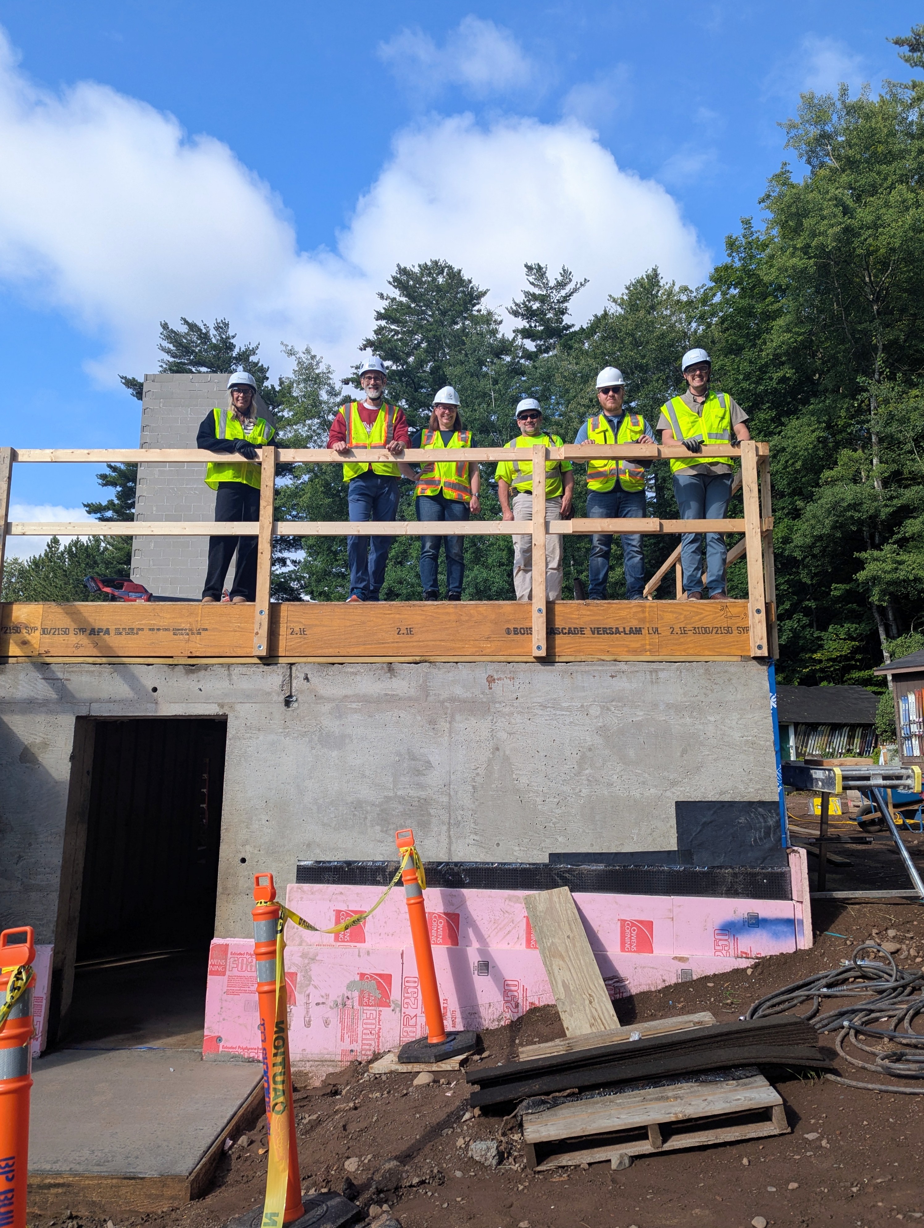 A group of construction workers standing atop the framing for the new chalet in Chester Park